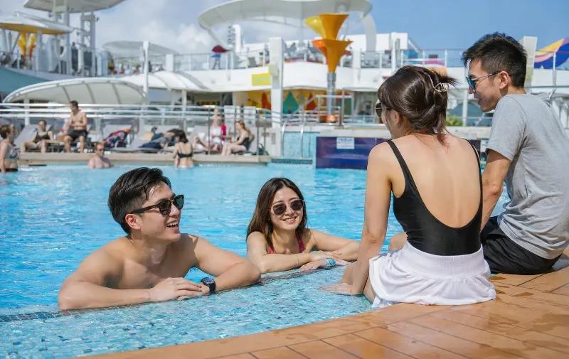 First-time cruisers enjoying the pool deck on the Genting Dream from Singapore